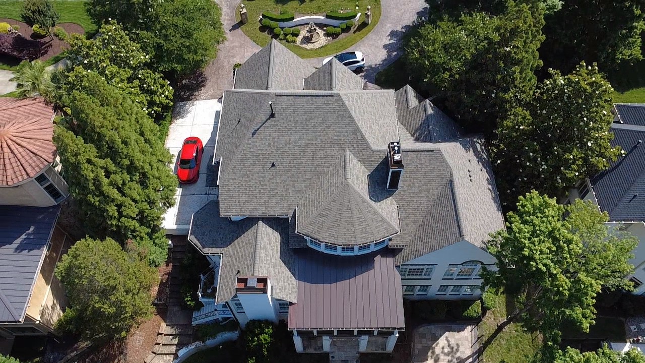 Top-down aerial view of a complex residential roof with multiple slopes and transitions