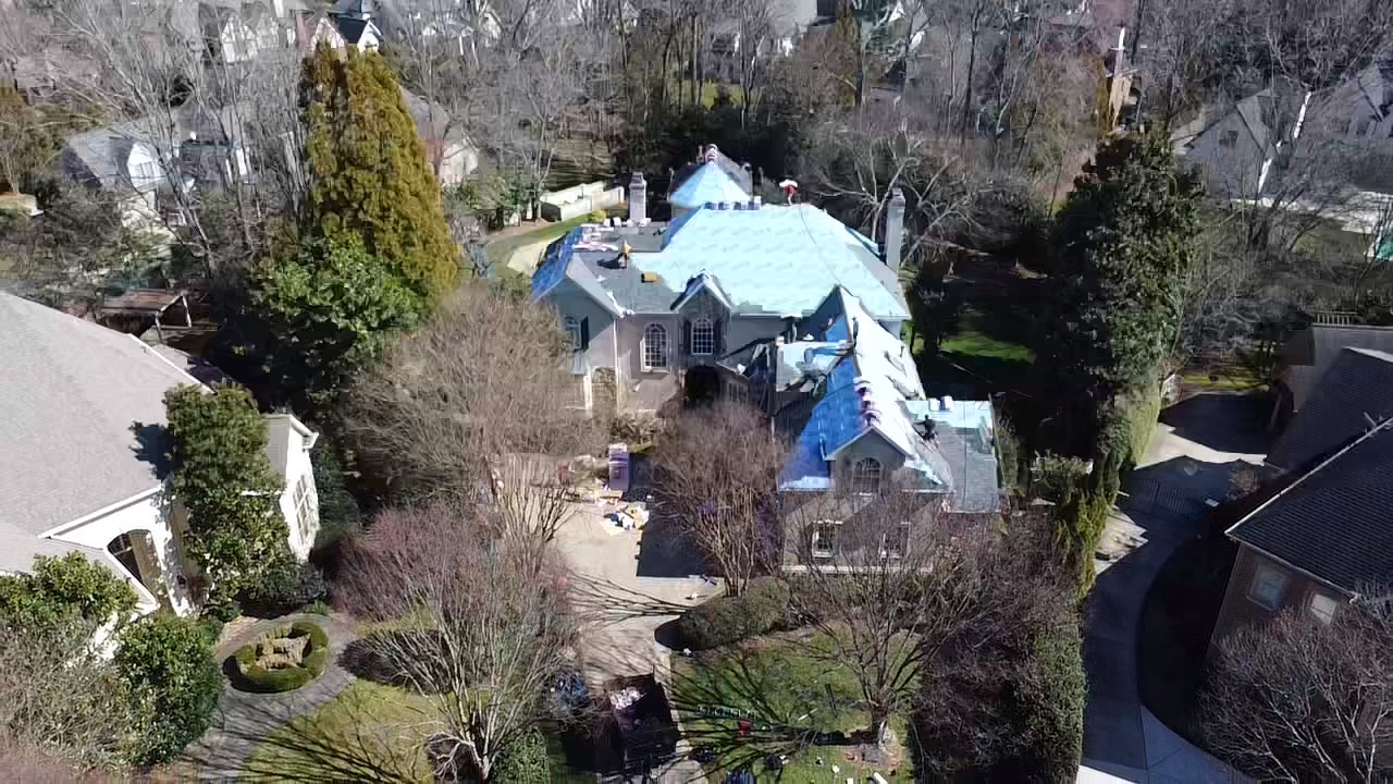 Aerial view of protective roof underlayment installed across a large estate during roof replacement