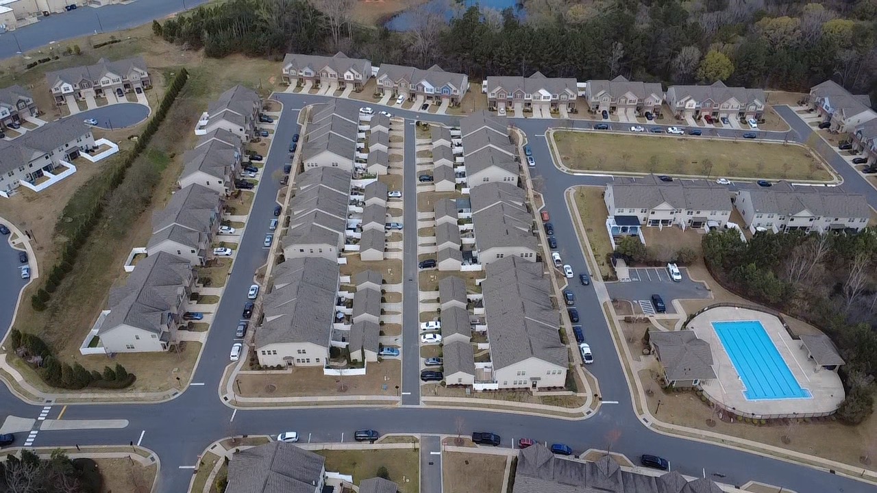 Aerial overview of a multifamily residential community with multiple roof systems and shared amenities