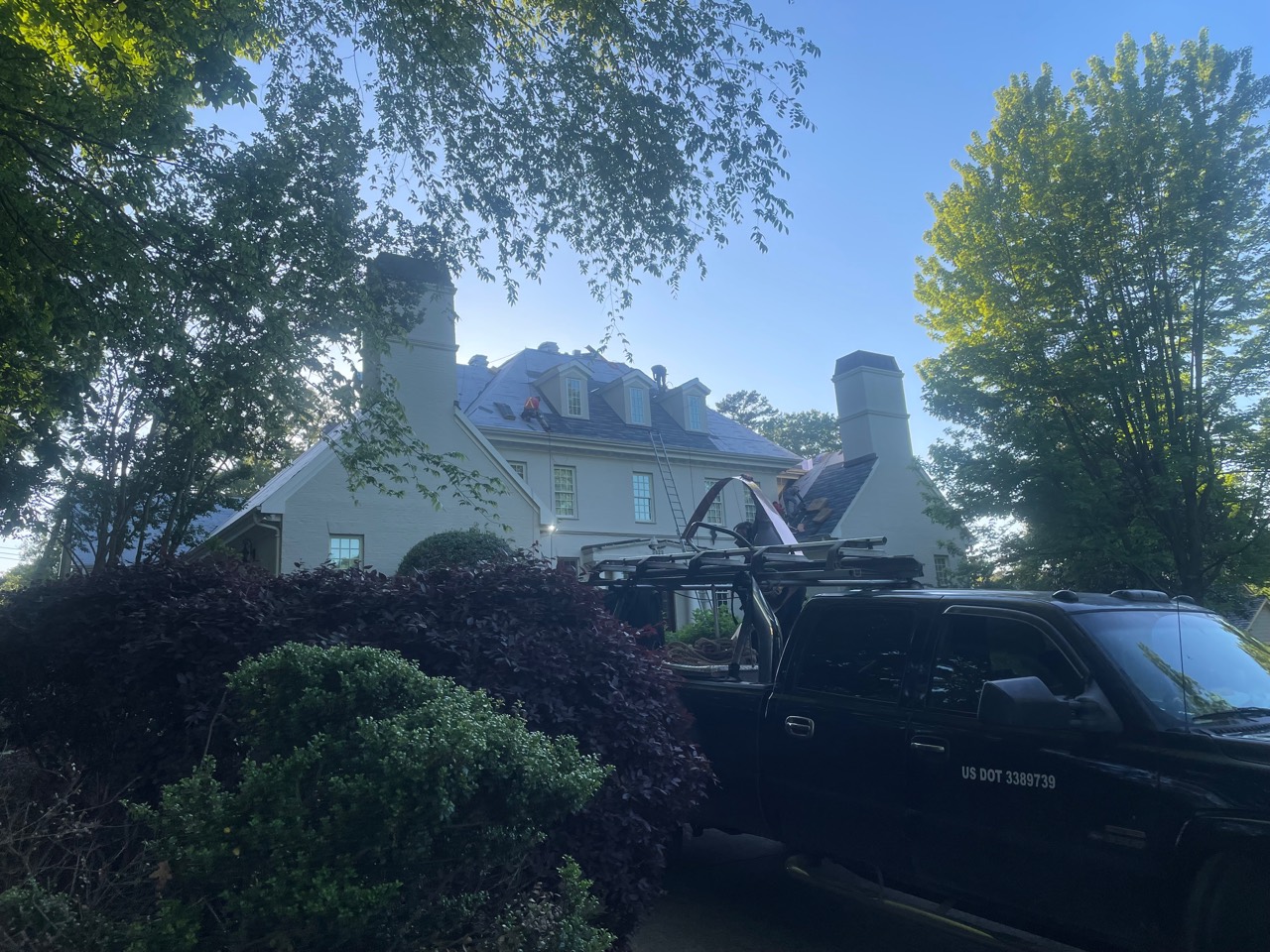 Ground-level view of the English Gray estate roofing work in progress