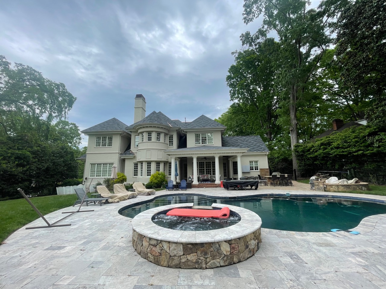 Poolside view showing the completed roof across multiple estate elevations